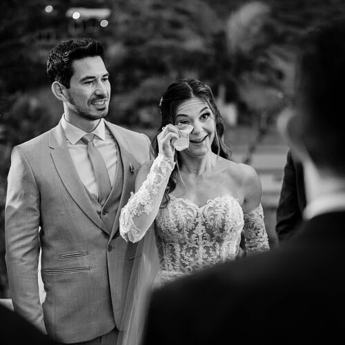 Wedding photo: bride wiping away tears, groom in light suit, outdoor evening ceremony, black and white portrait, emotional wedding moment | Diego Pereira Da Silveira, Tijucas, Brazil