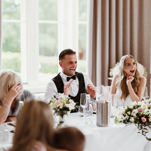 Düğün fotoğrafı: wedding reception table, guests laughing at speech, man in tuxedo speaking, elegant floral centerpieces, bright natural window light | James Hatter, London, Birleşik Krallık