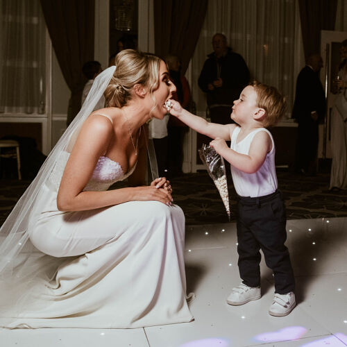 Düğün fotoğrafı: bride in white gown, young child dancing, elegant ballroom reception, lit dance floor, bride and child interaction, formal wedding celebration | James Hatter, London, Birleşik Krallık