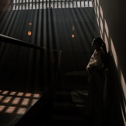結婚式の写真: bride in dramatic light, silhouette against window, rays through blinds, contemplative moment indoors, bride holding bouquet, architectural interior setting | Eric Corbacho, São Paulo, ブラジル