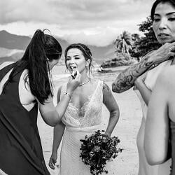 結婚式の写真: bride with bouquet laughing, bridesmaids gathered on beach, tropical mountains and water backdrop, black and white wedding portrait | Danilo &amp; Cris Almeida, Mogi das Cruzes, ブラジル